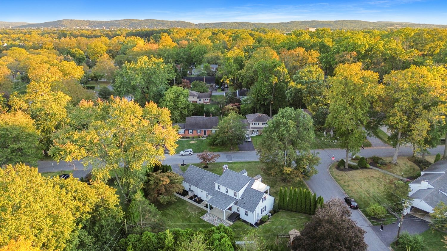 Panoramic mountain landscape view of a residential area surrounded by fall colors.