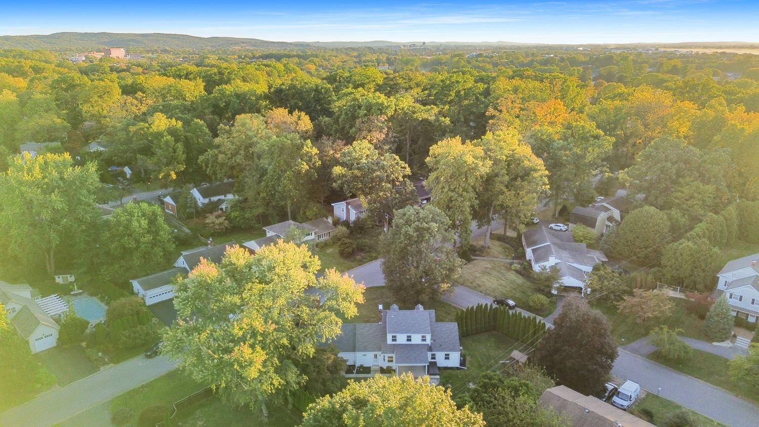 Drone shot of rural homes and properties with vibrant fall foliage.