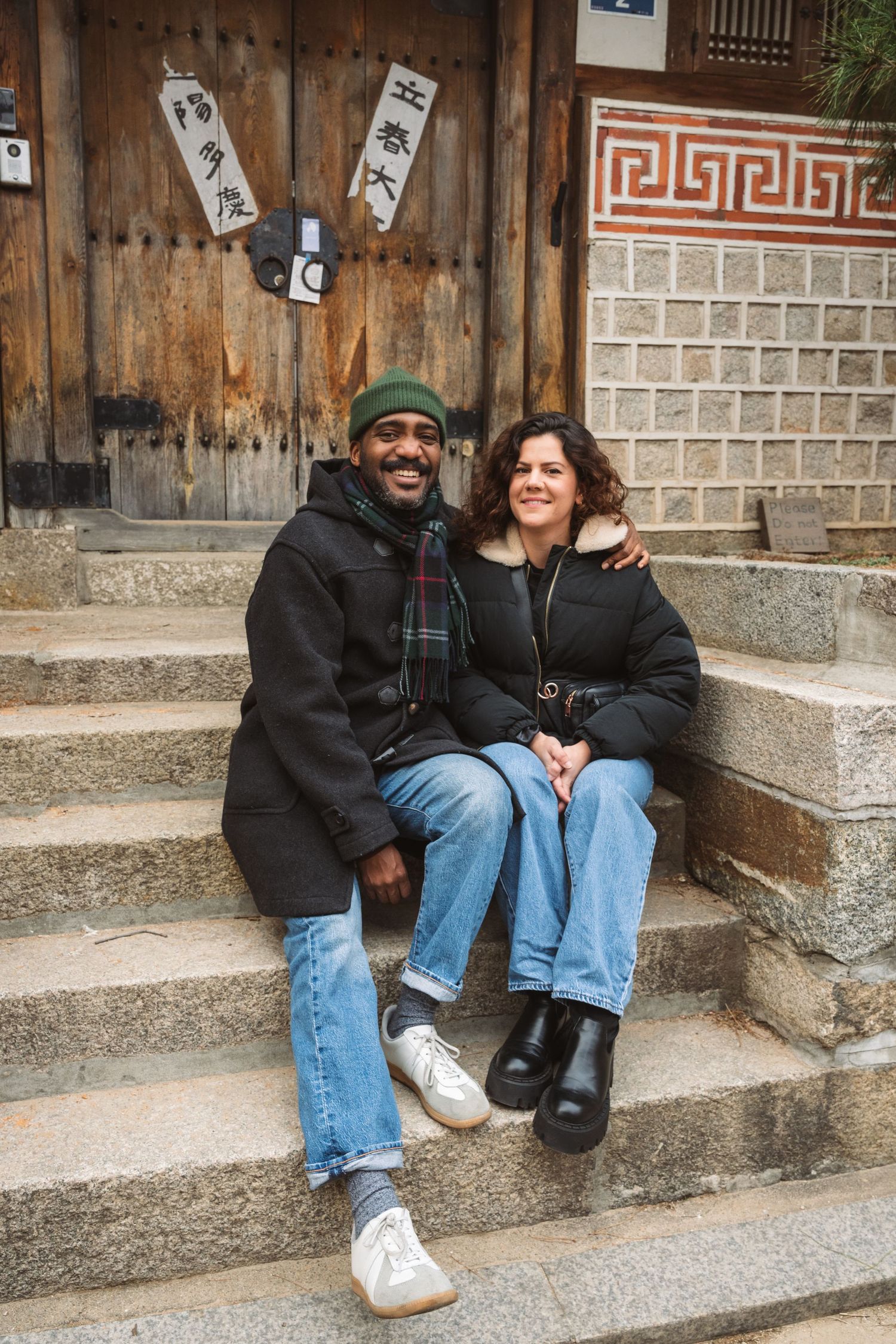 Two people sitting together on concrete steps sharing a laugh and enjoying each other's company.