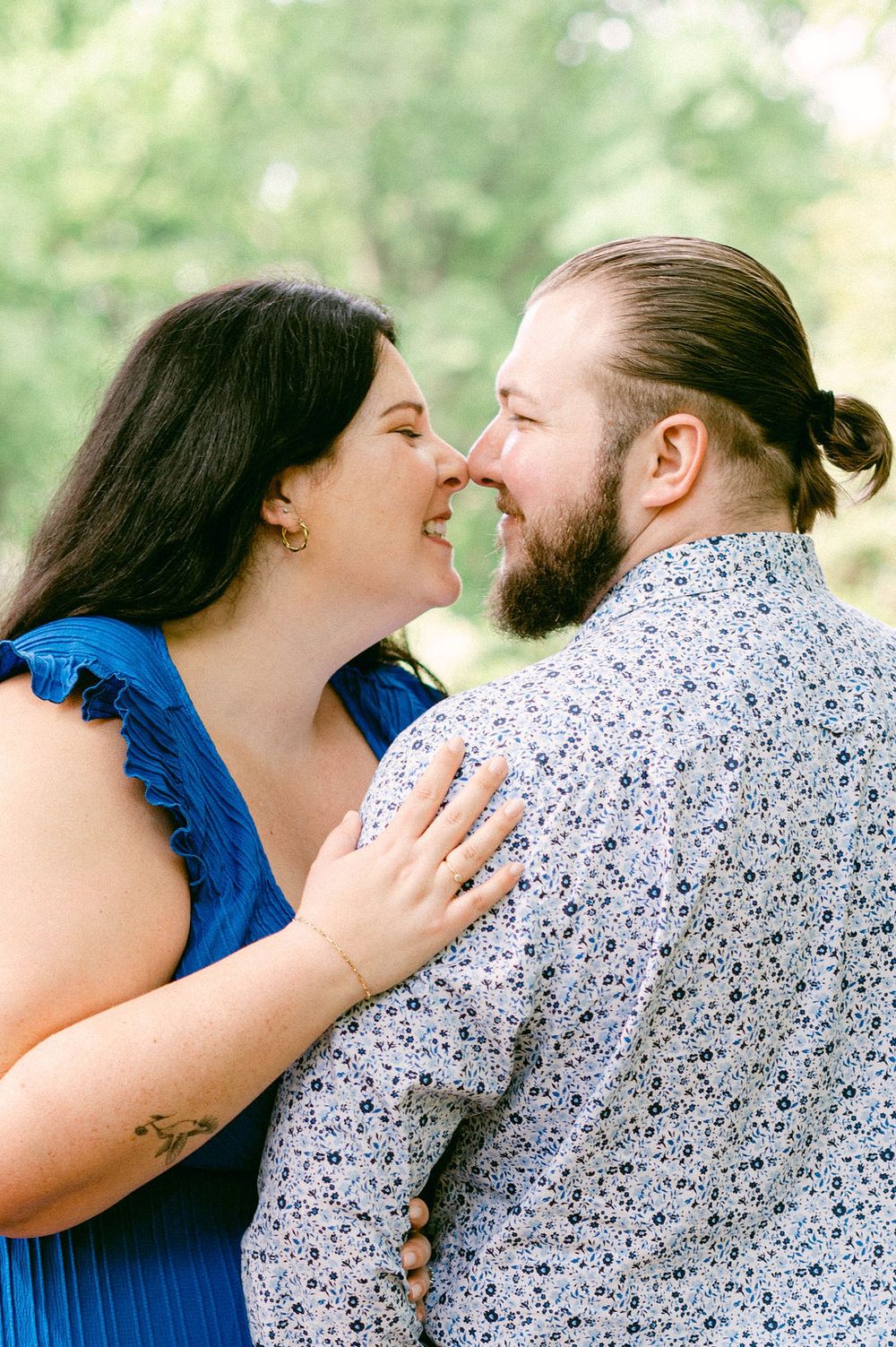 Romantic couple sharing intimate moments and kisses while wearing coordinated blue and floral outfits.