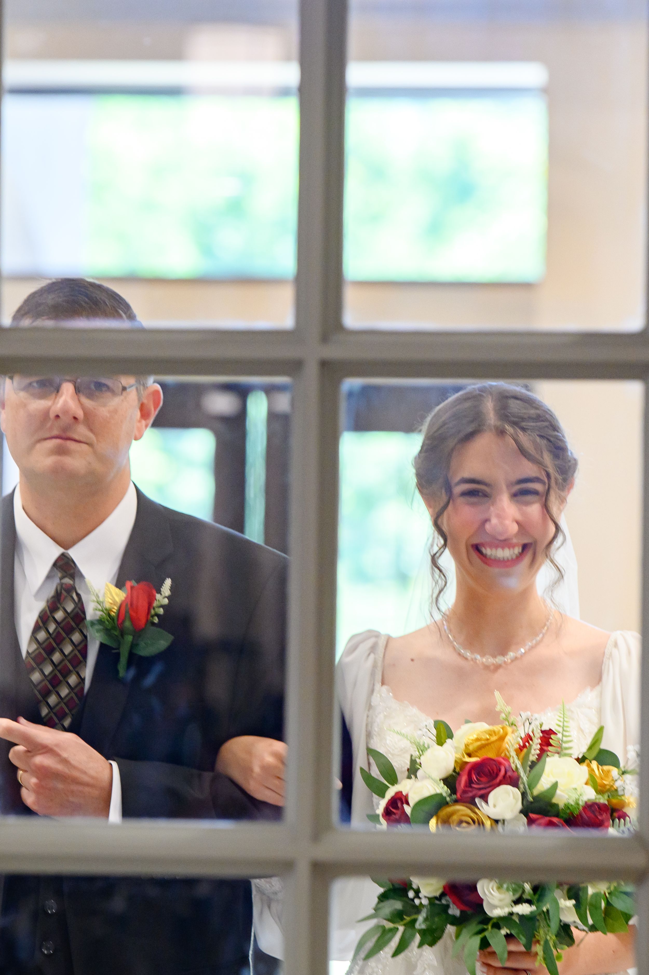 bride entrance with father through window panes with bright smiles and floral bouquets in a candid moment in atlanta, ga