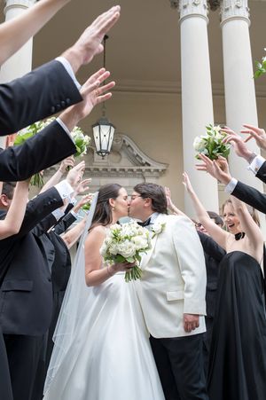 Wedding party celebrates with raised arms and joyful poses against white columns in a sequence of candid shots at biltmore ballrooms wedding
