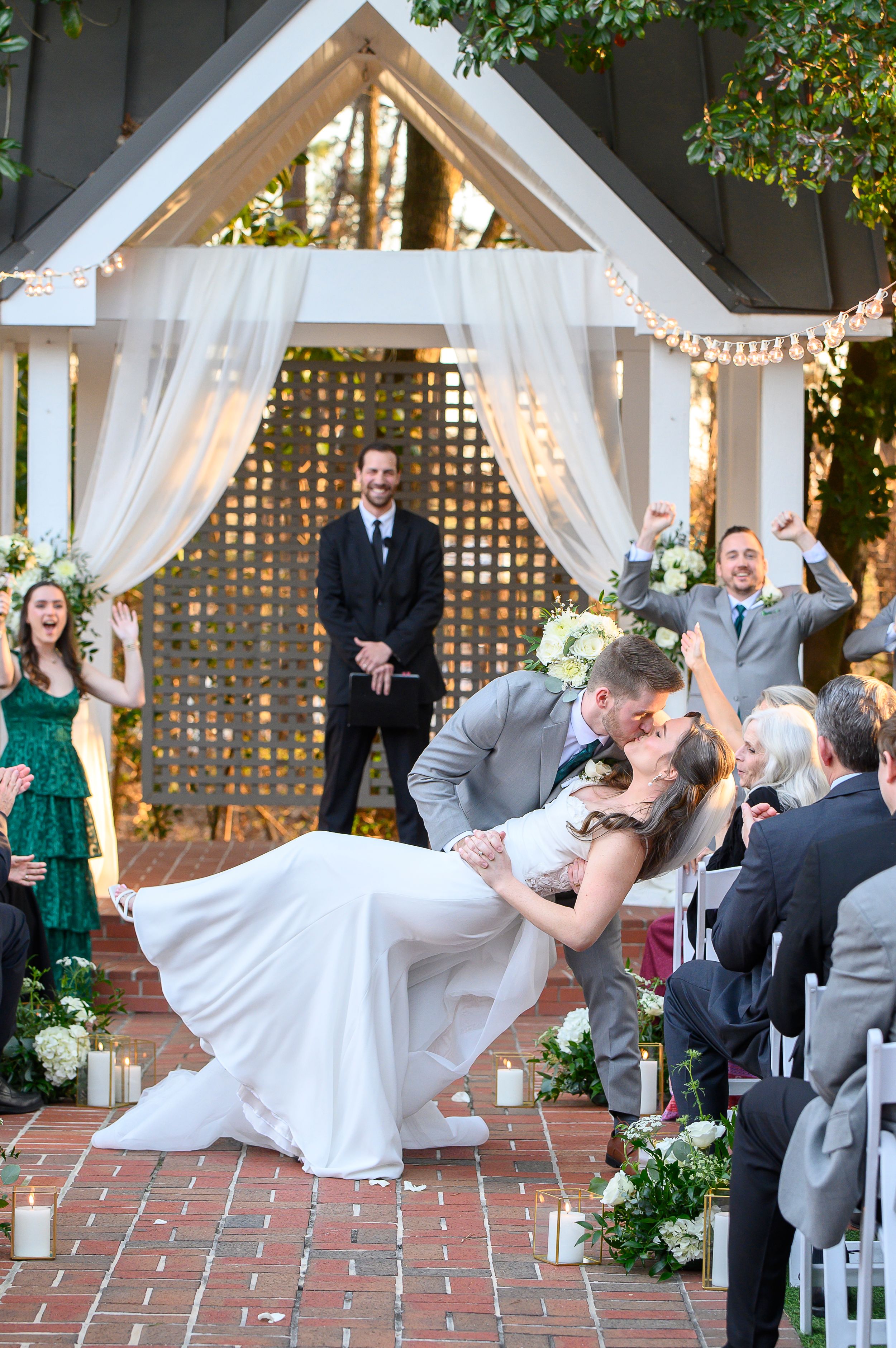 A sequence of photos showing a wedding couple performing a dramatic dip dance move on a brick patio under string lights at flint hill
