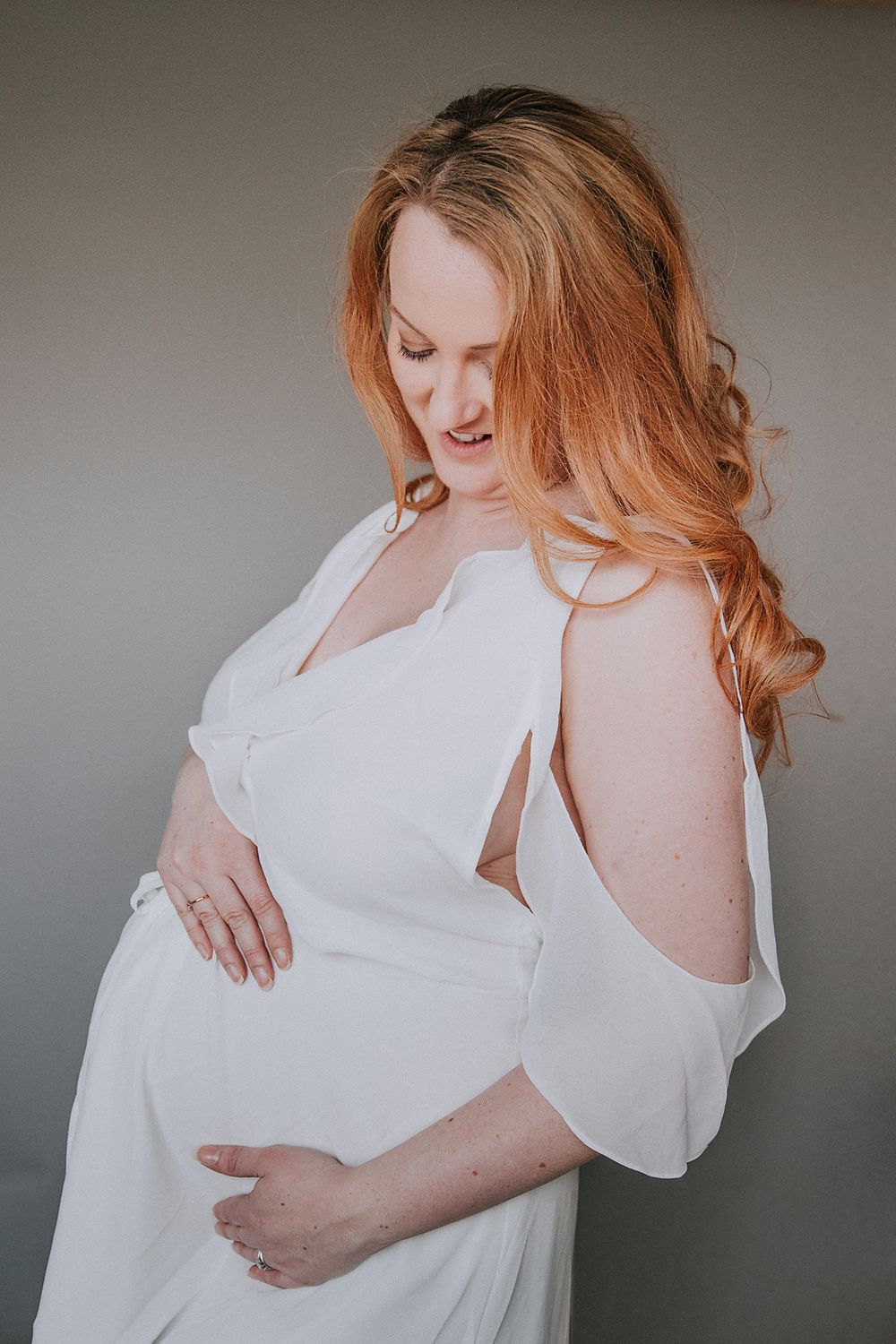 A series of maternity photos showing a pregnant woman in a flowing white dress against a neutral background.