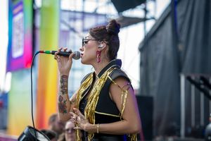 Musicians perform on stage with saxophones and other instruments at an outdoor music festival.