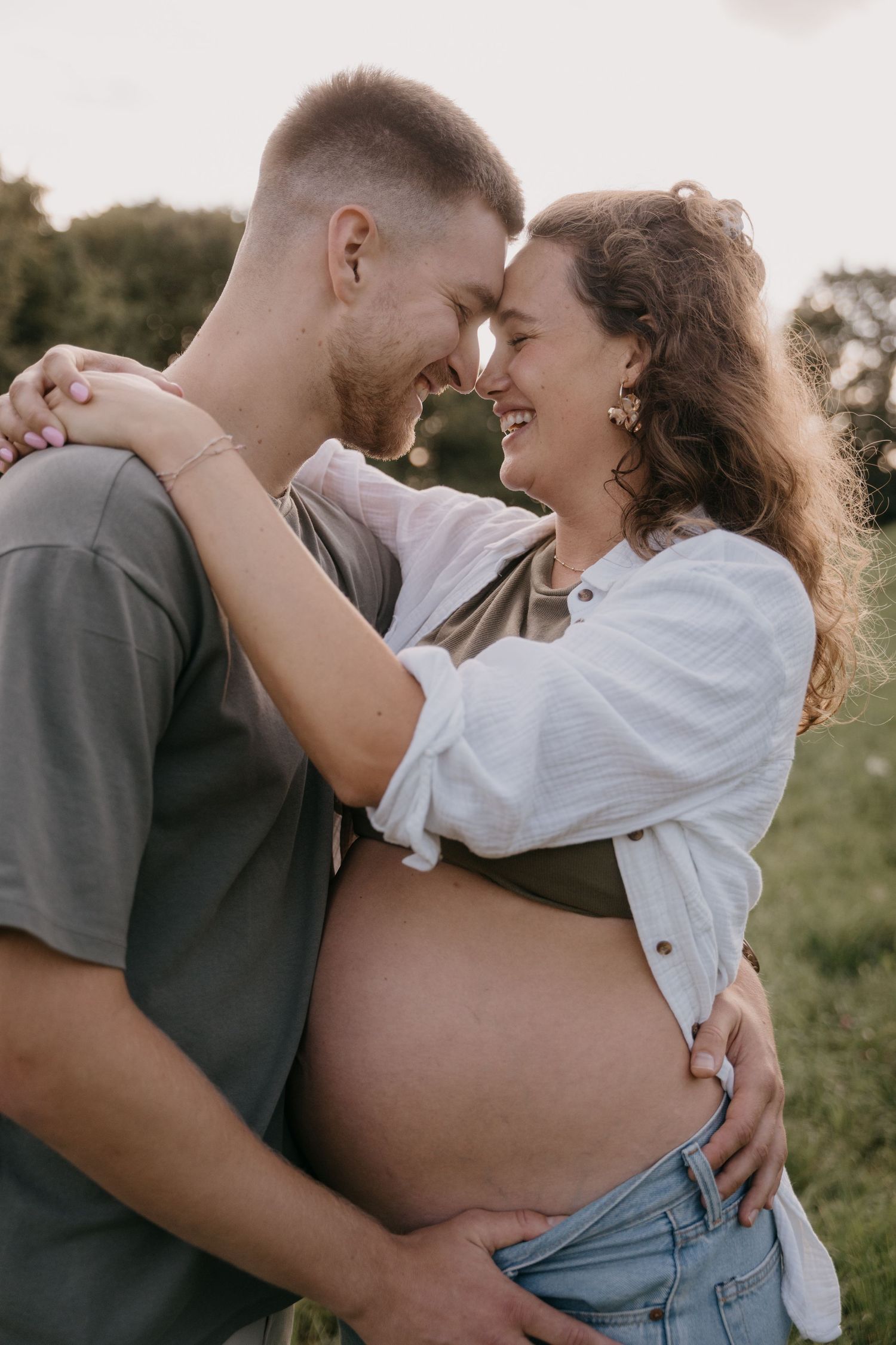 A couple embraces tenderly in a series of romantic outdoor photos at sunset.