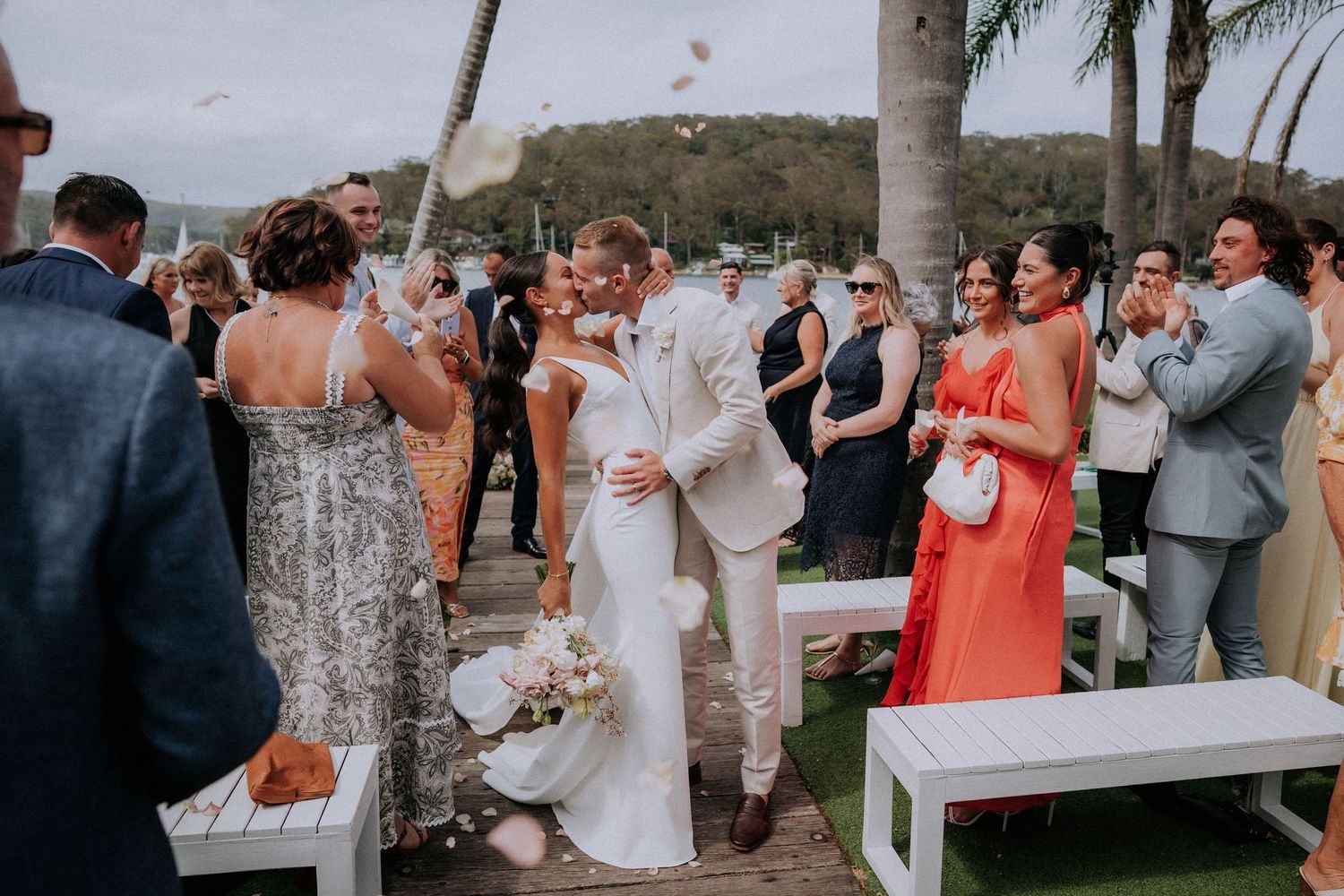 Wedding celebration with guests gathered outdoors at a tropical venue.
