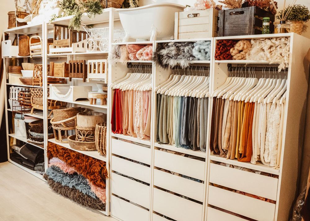 Modern retail clothing store interior with organized racks of colorful garments and bright lighting.