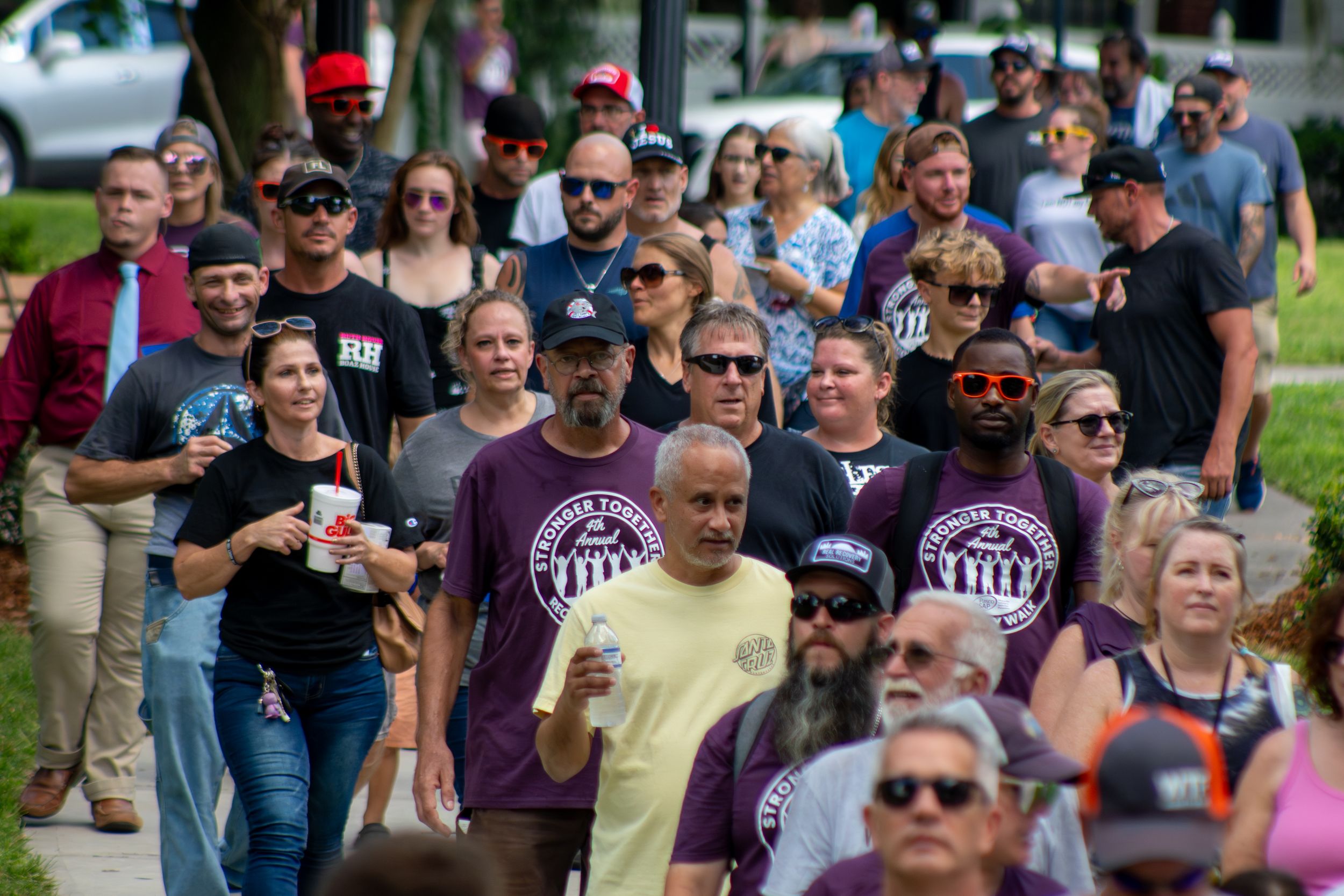A large crowd of people gathered outdoors for a public event on a sunny day.