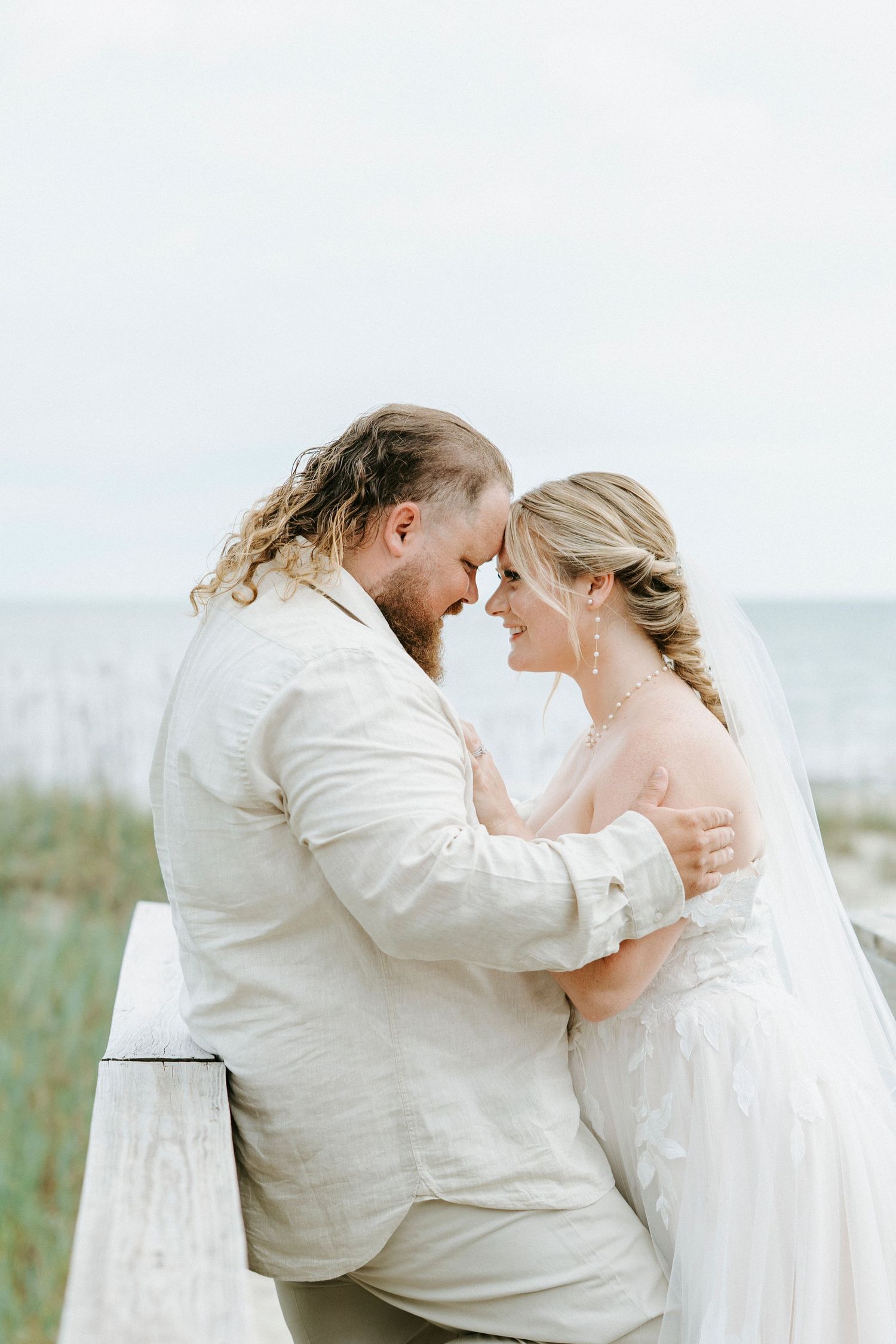 A romantic beachside moment captured in a series of intimate wedding photos against the ocean backdrop.