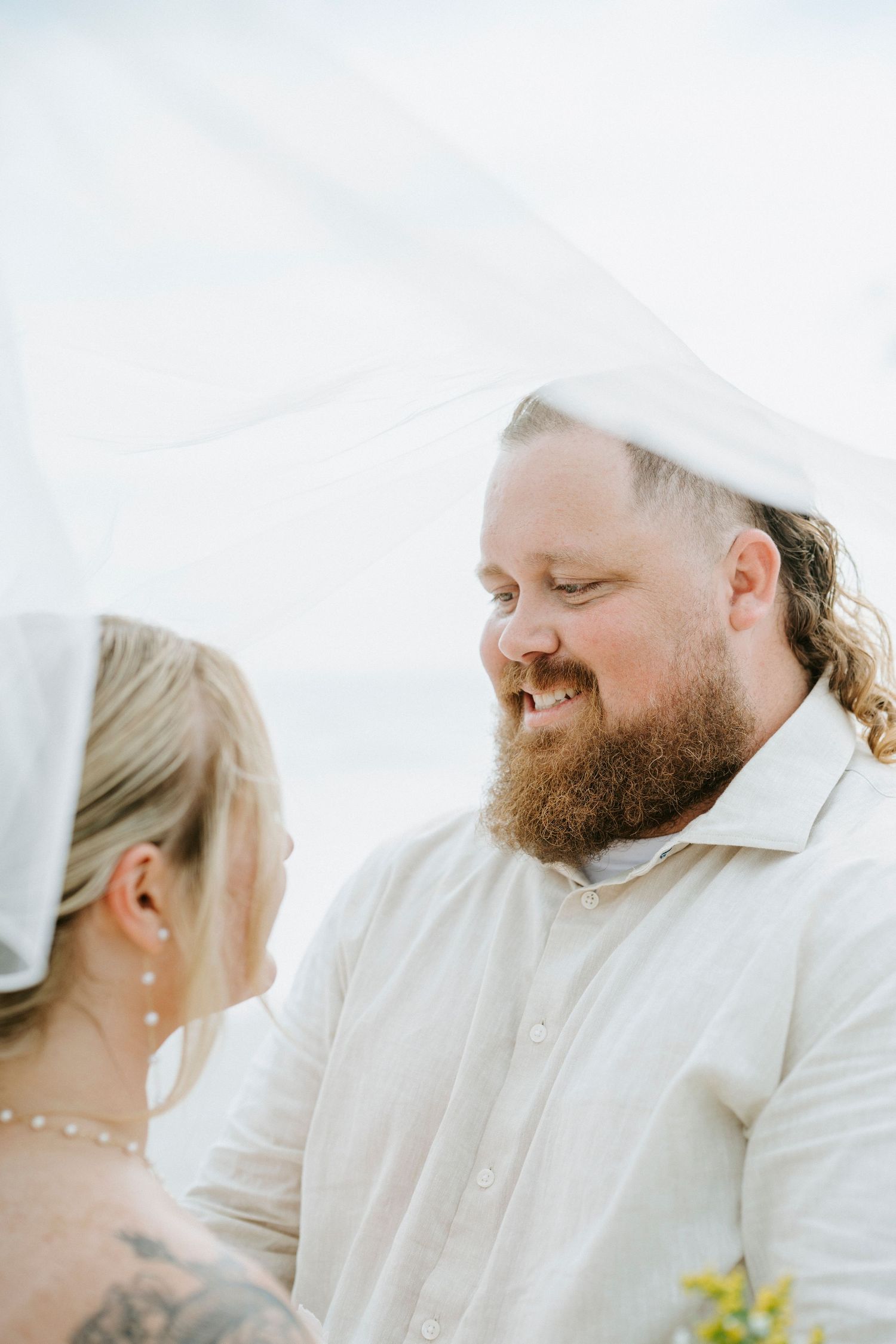 Close-up candid shots of a couple sharing joyful moments during their beach wedding ceremony.