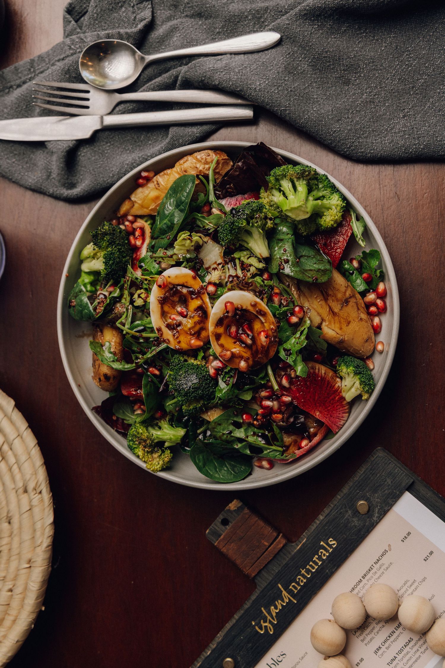 Colorful salad with grilled vegetables and broccoli served on dark wooden table.