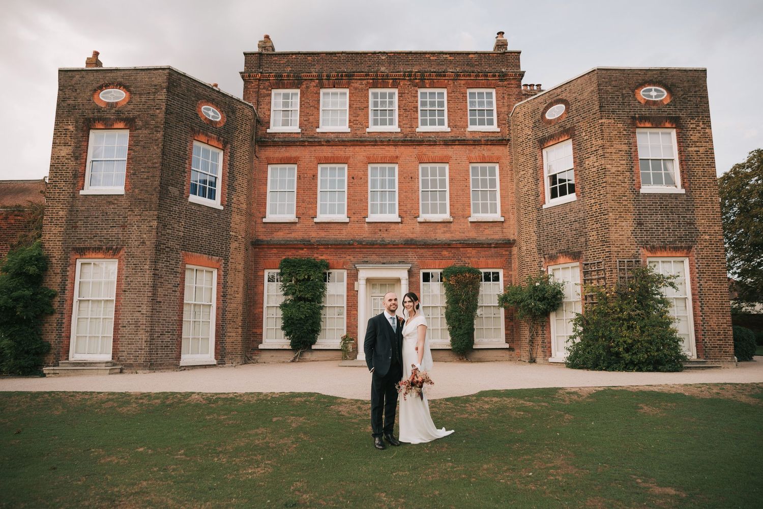 A panoramic view of a historic brick mansion with Georgian-style windows and architectural details.