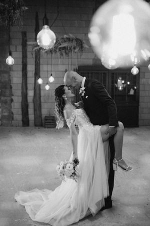 Romantic black and white dance scene with hanging lights and flowing dress.