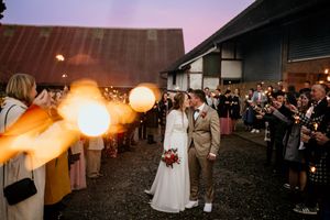 Wedding celebration at sunset with string lights creating a warm ambiance outdoors.