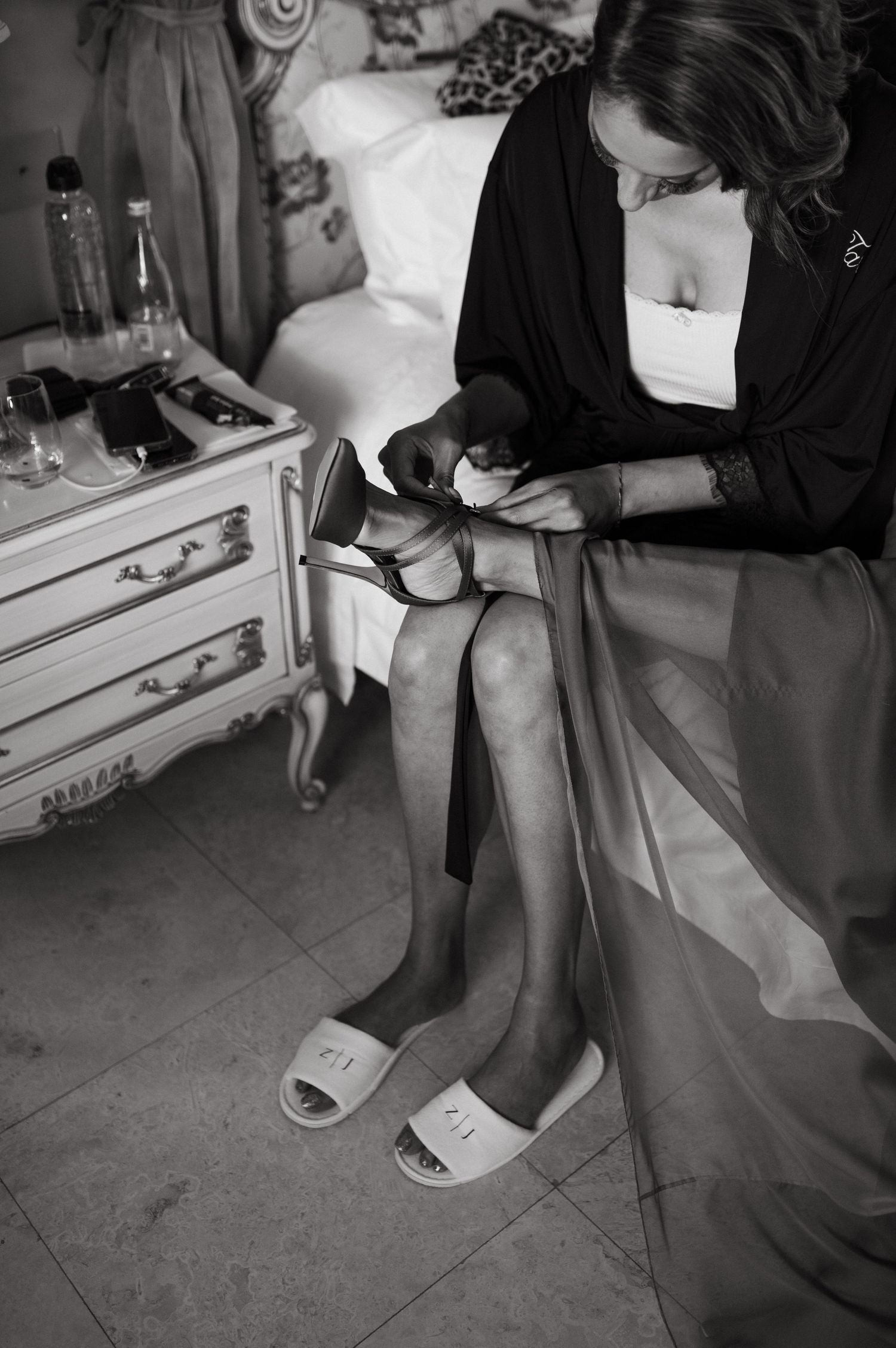 Black and white photo series showing someone putting on stockings and shoes in elegant vintage style.