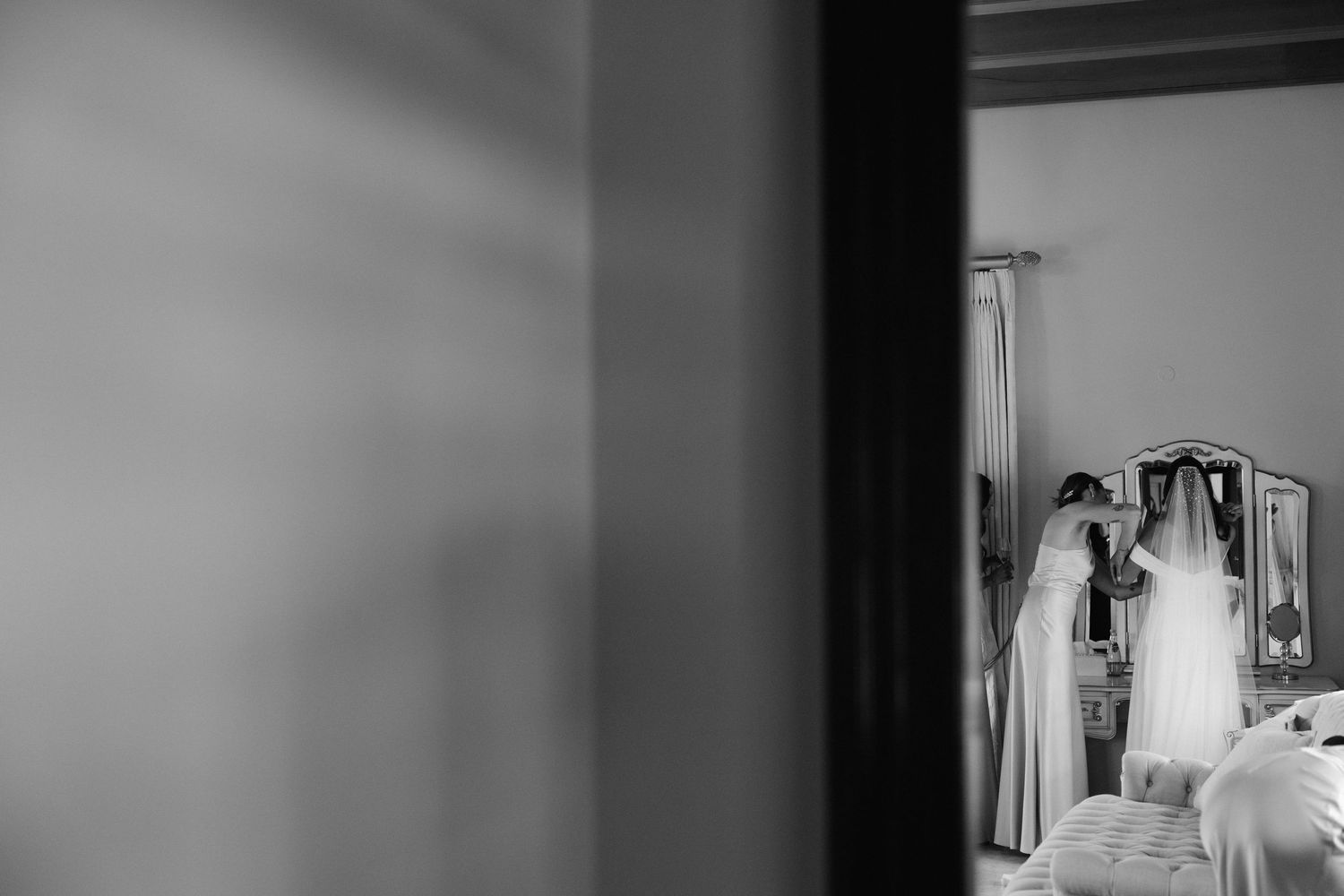 Artistic black and white wedding photograph capturing a bride's reflection in multiple mirrors.