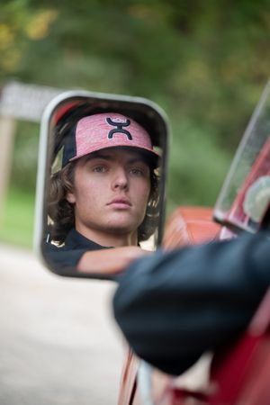 Close up view of side mirror reflection on red truck.