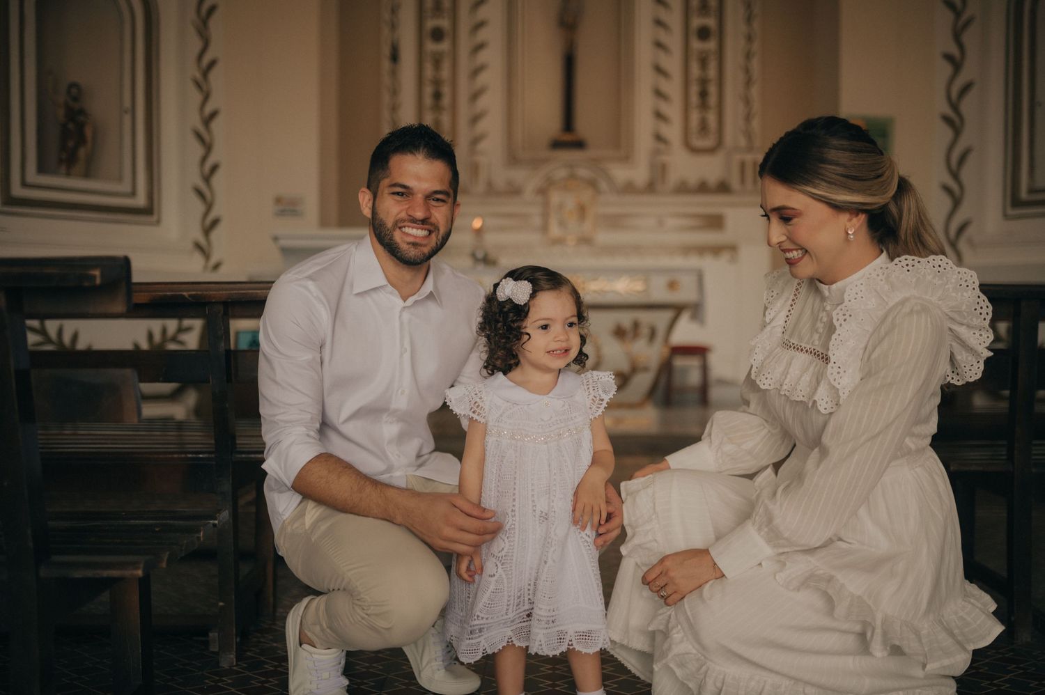 An intimate family portrait in an ornate church setting with classical architectural details.