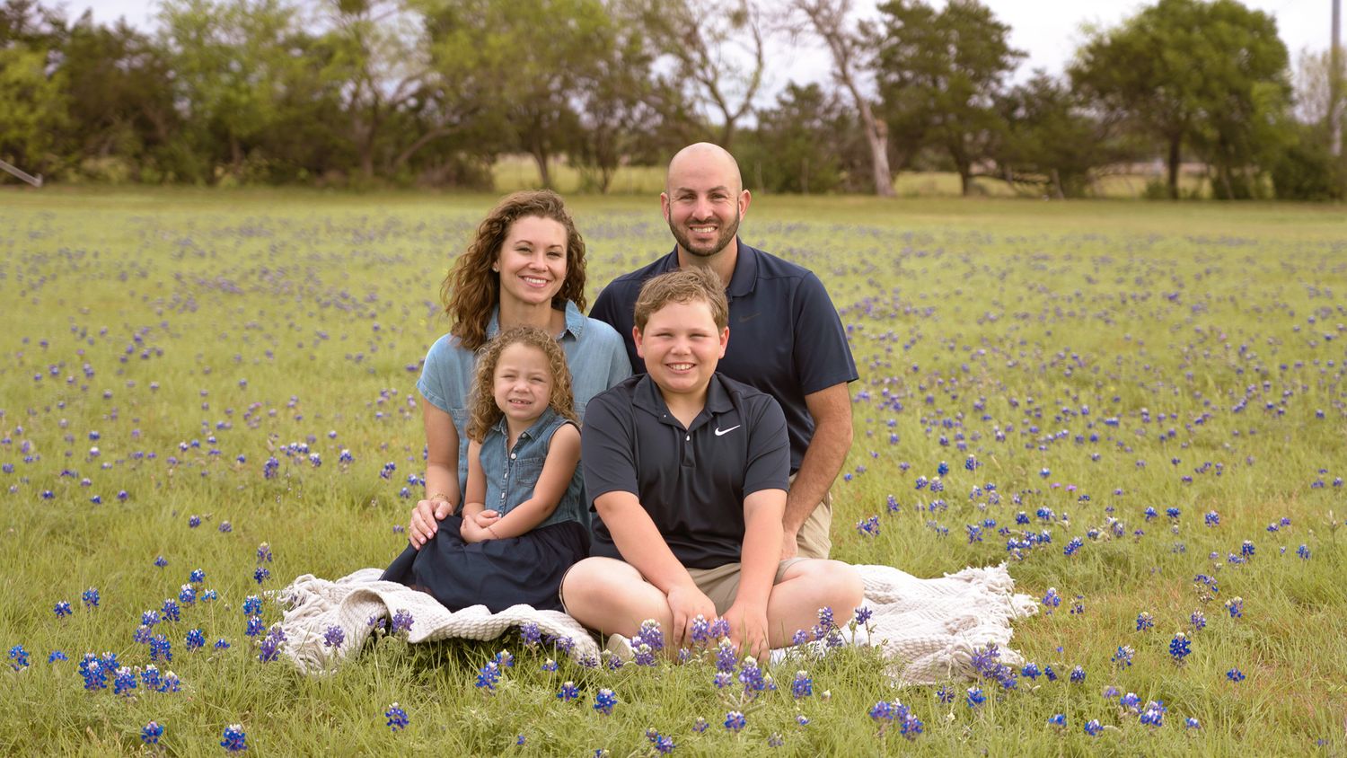 Family group photo with cowboy hats gathered together outdoors.