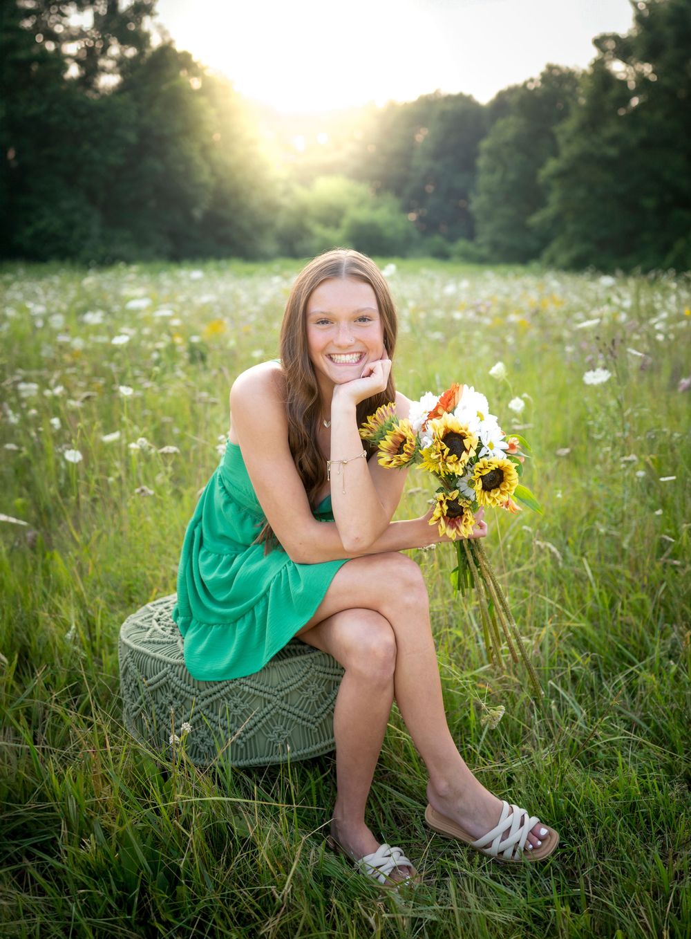 Outdoor portrait session in a wildflower meadow at golden hour with sunflowers.