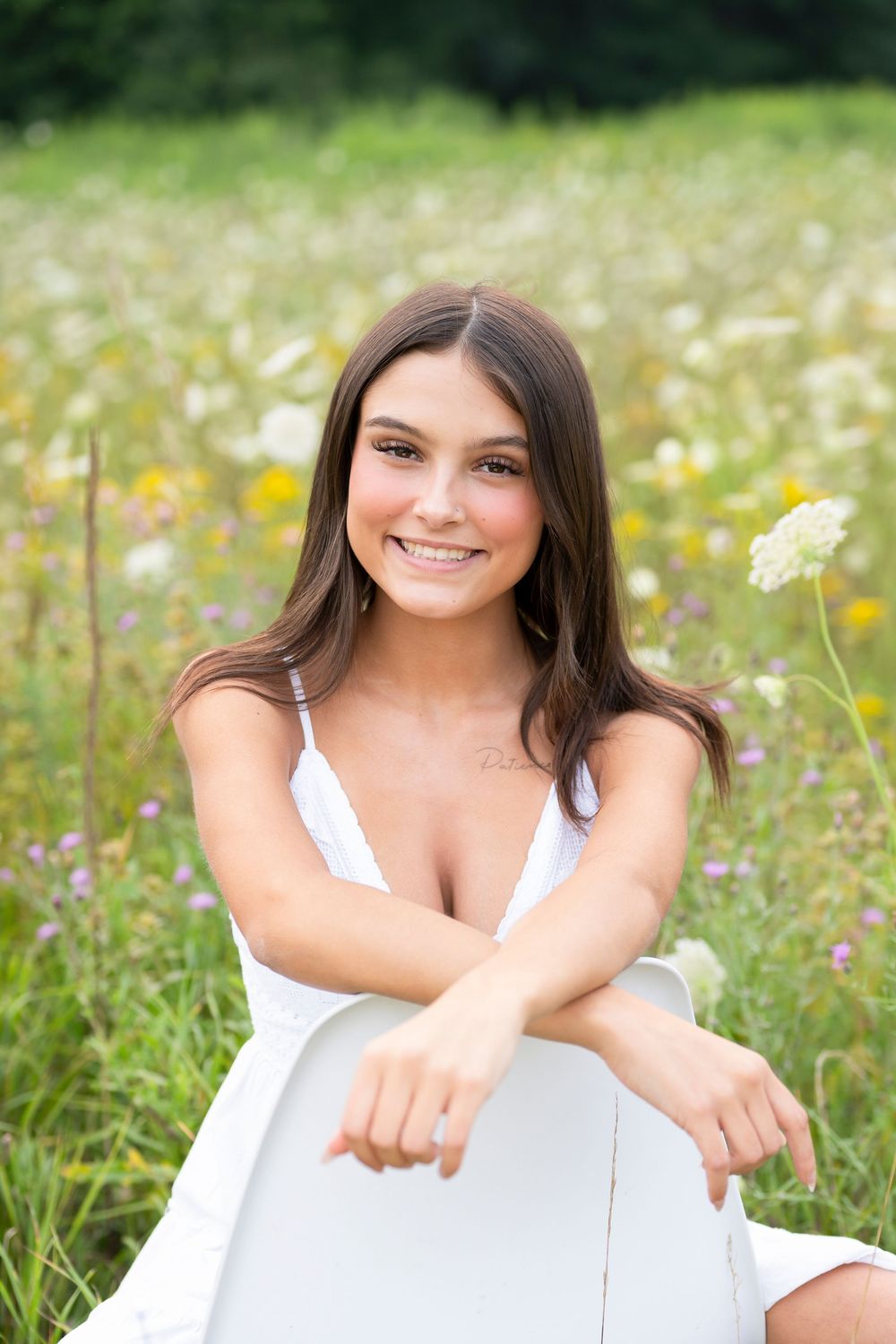 A portrait in a wildflower meadow with white dress against a natural summer background.
