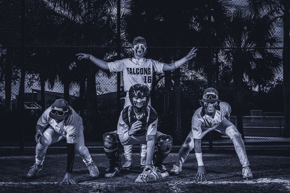 Group of baseball players pose in dramatic defensive stance formation.