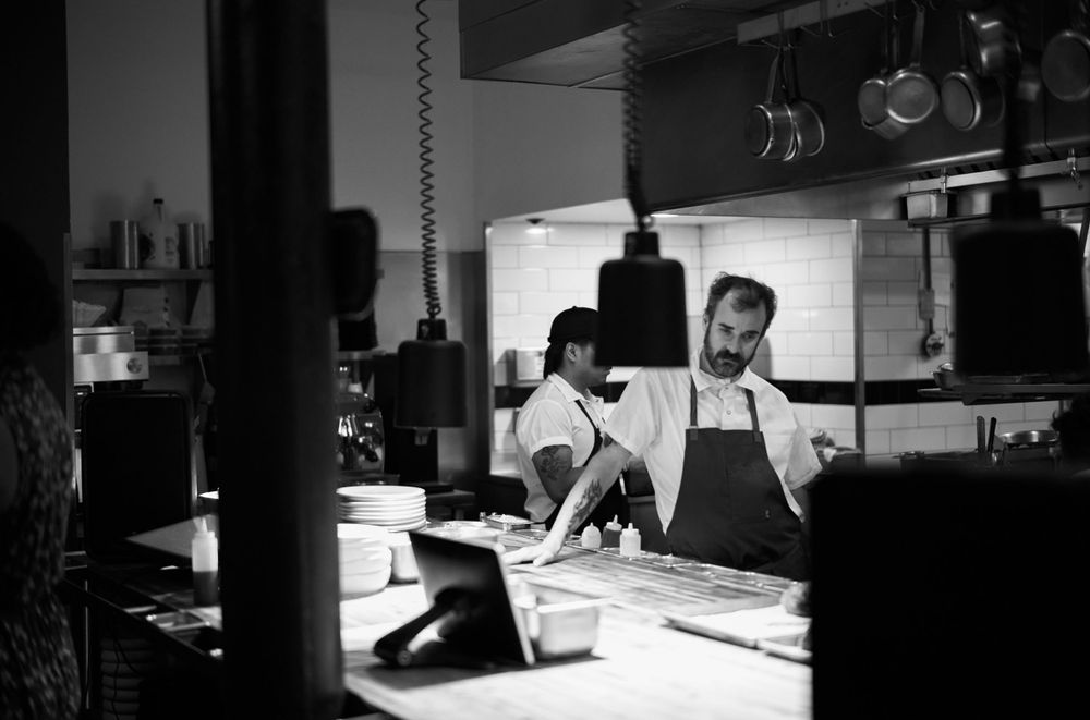 Black and white photo of chefs working in a restaurant kitchen.