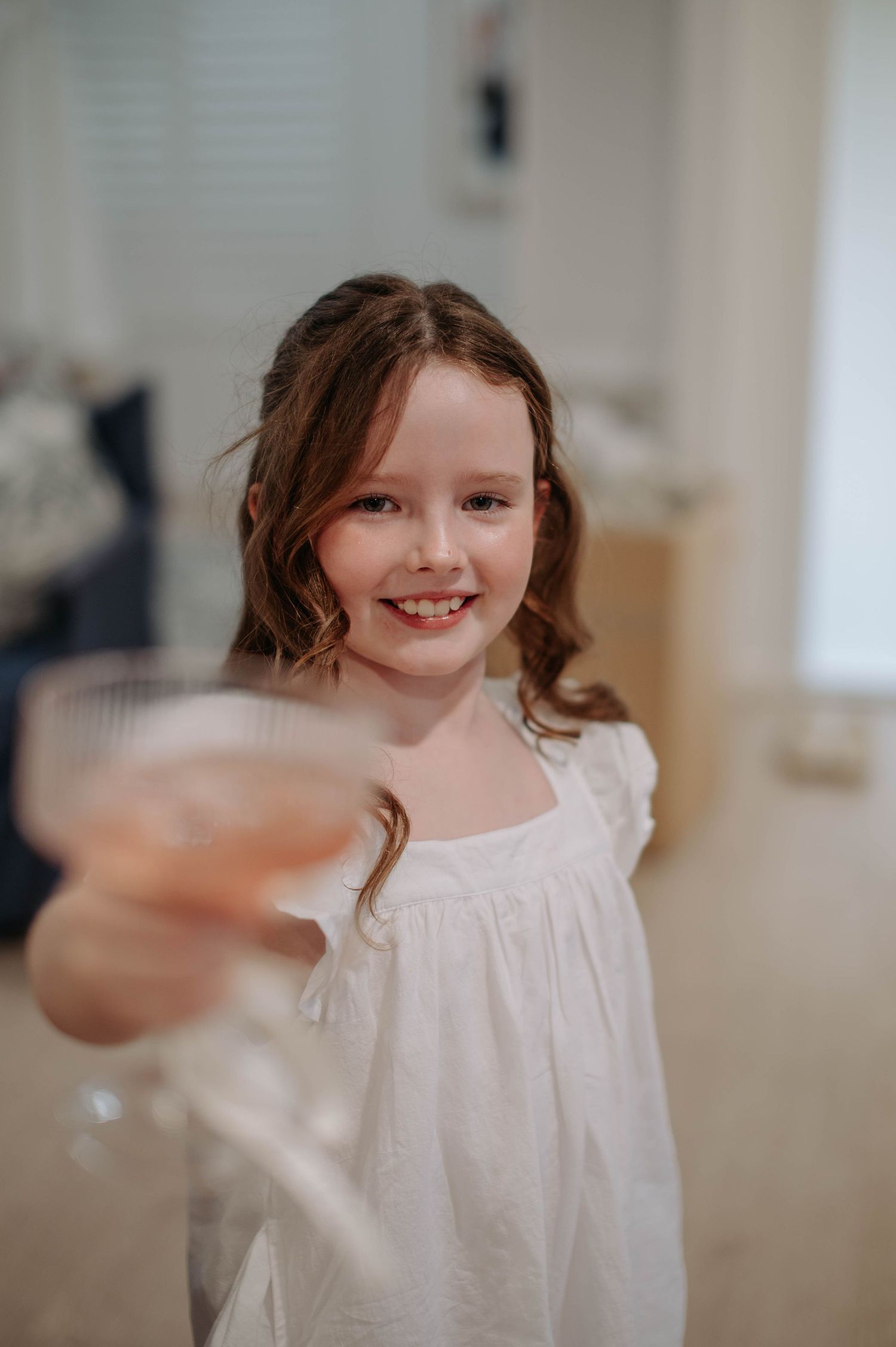 A sequence of images showing a child in a white dress making joyful expressions with a blurred background.