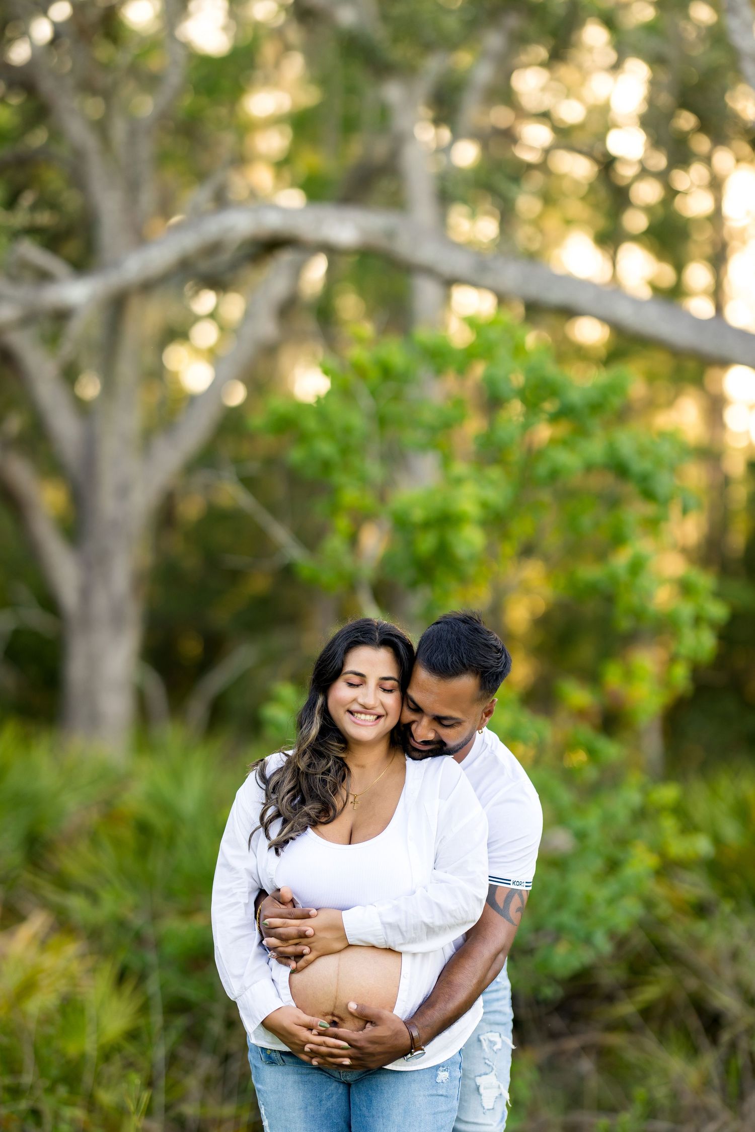 Joyful maternity moment captured in natural outdoor setting with greenery. Photos by Tampa Photographer DigitalMyst Photography