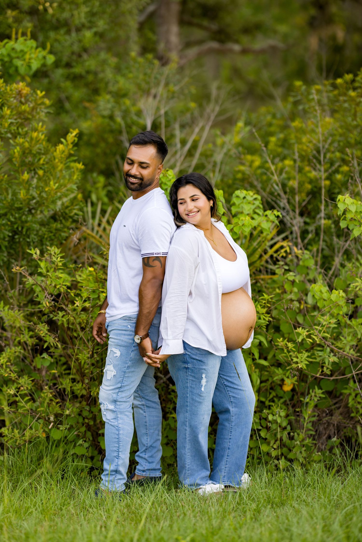 Natural outdoor pregnancy photoshoot with couple in coordinated casual outfits. Photos by Tampa Photographer DigitalMyst Photography