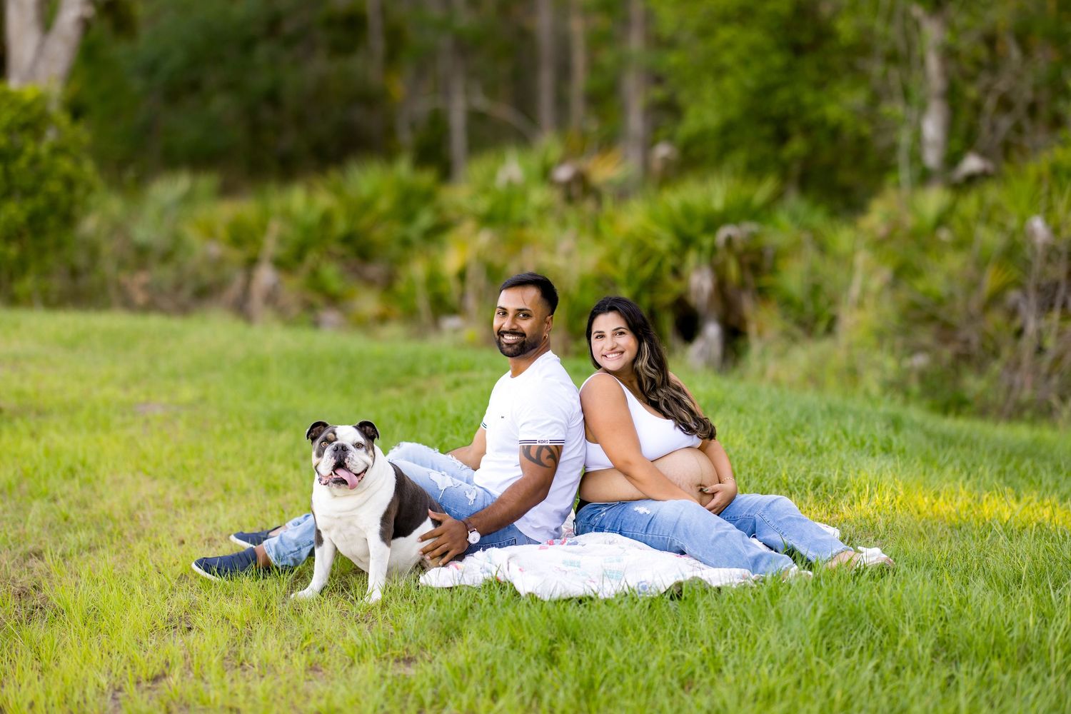 A couple lounges on grass during their maternity photo session with their dog beside them. Photos by Tampa Photographer DigitalMyst Photogra