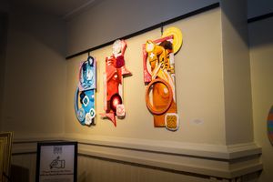 Illuminated wall art featuring vibrant figures in blue, red, and orange tones.
