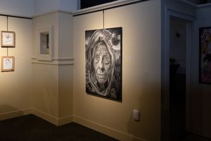 Gallery wall displaying a dramatic black and white portrait in low lighting.