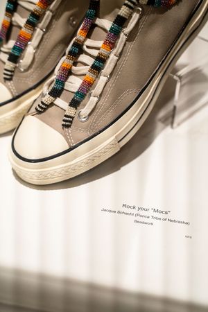 Vintage-style sneakers with colorful beaded laces displayed against white background.
