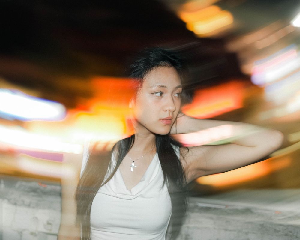 Motion-blurred photos of a figure in a white tank top performing a graceful dance sequence with dynamic movements.