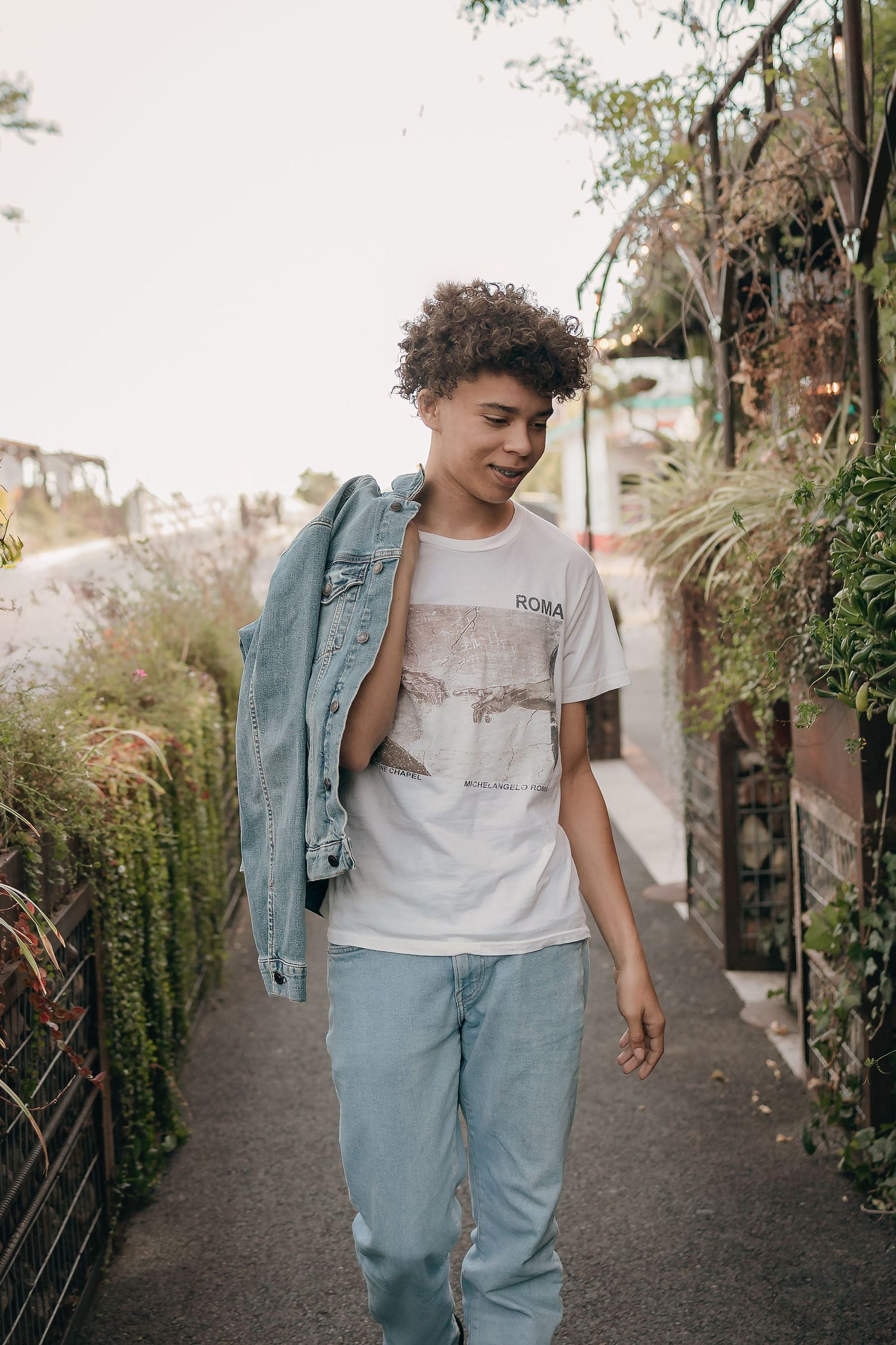 Black male high school student walks in downtown Winters for senior portrait photo shoot