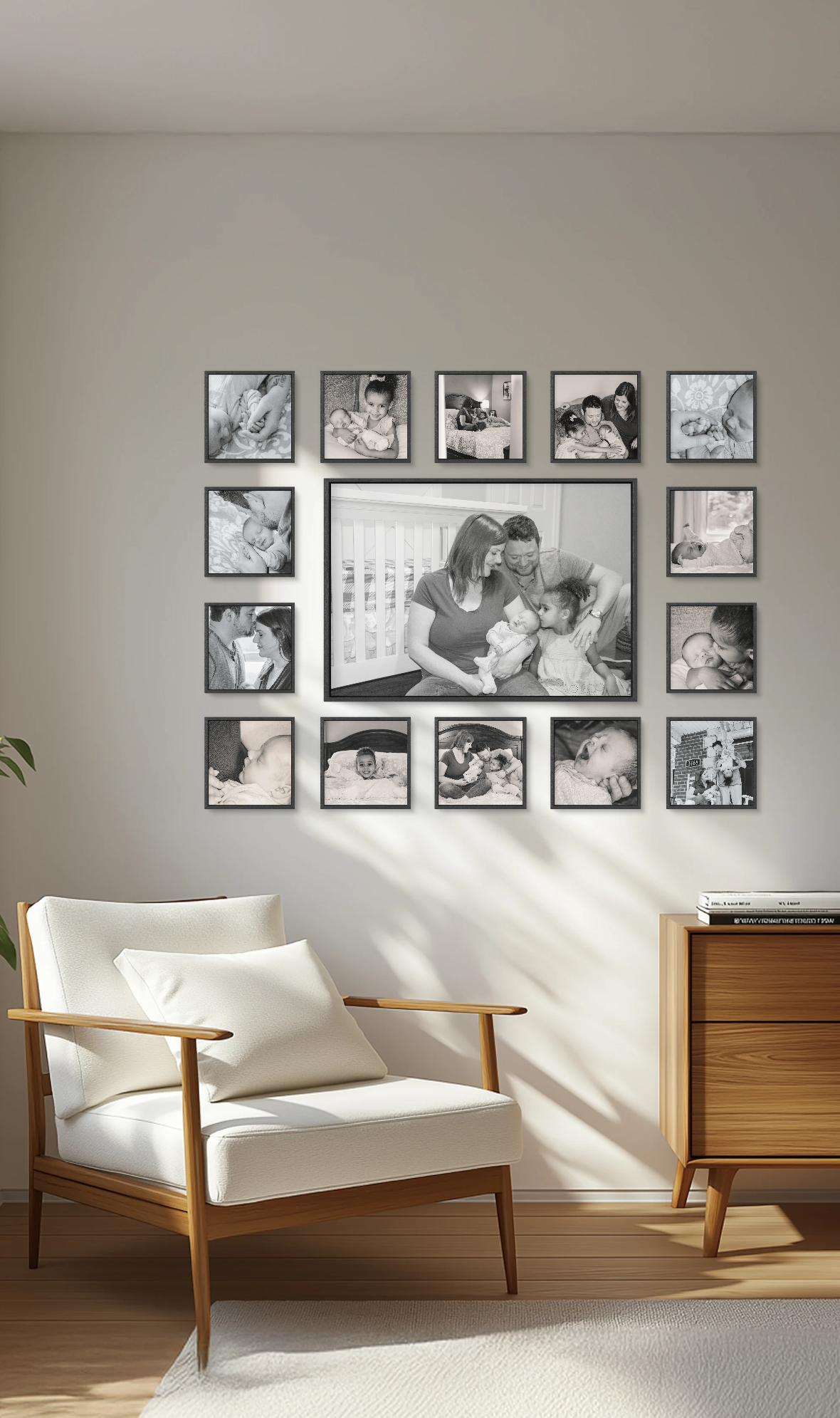 Modern living room with a large black & white gallery wall of family photos above a white accent chair, capturing newborn & sibling moments