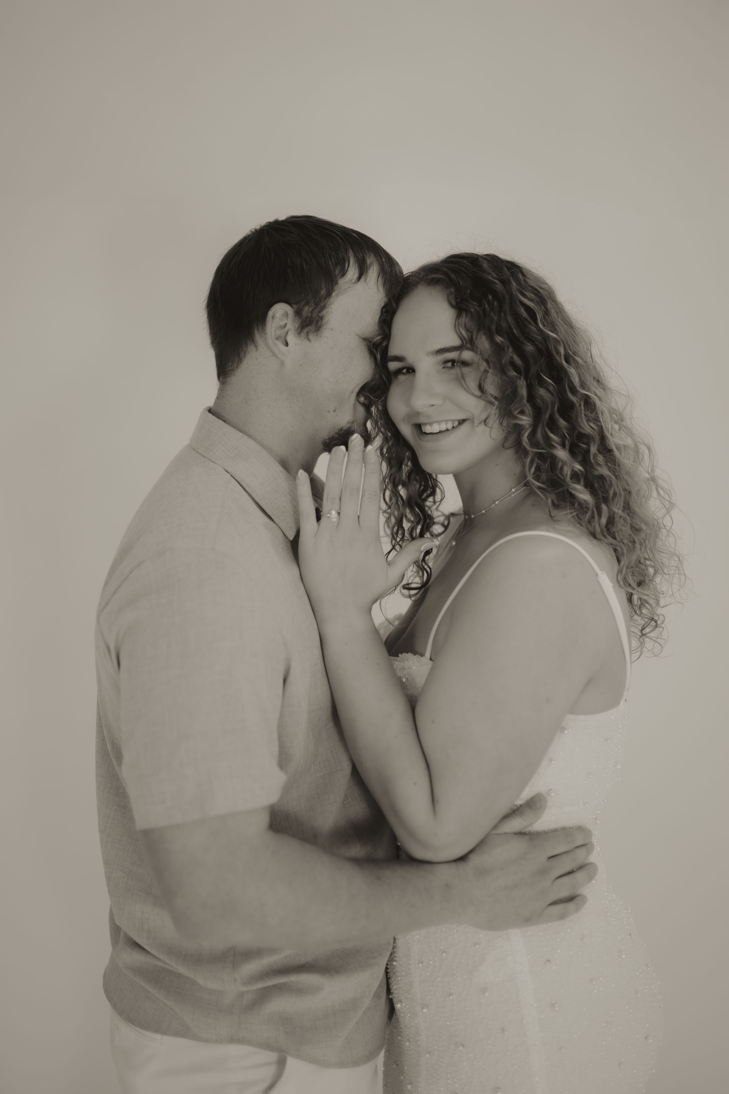Intimate black and white photo series showing tender moments between a couple embracing.