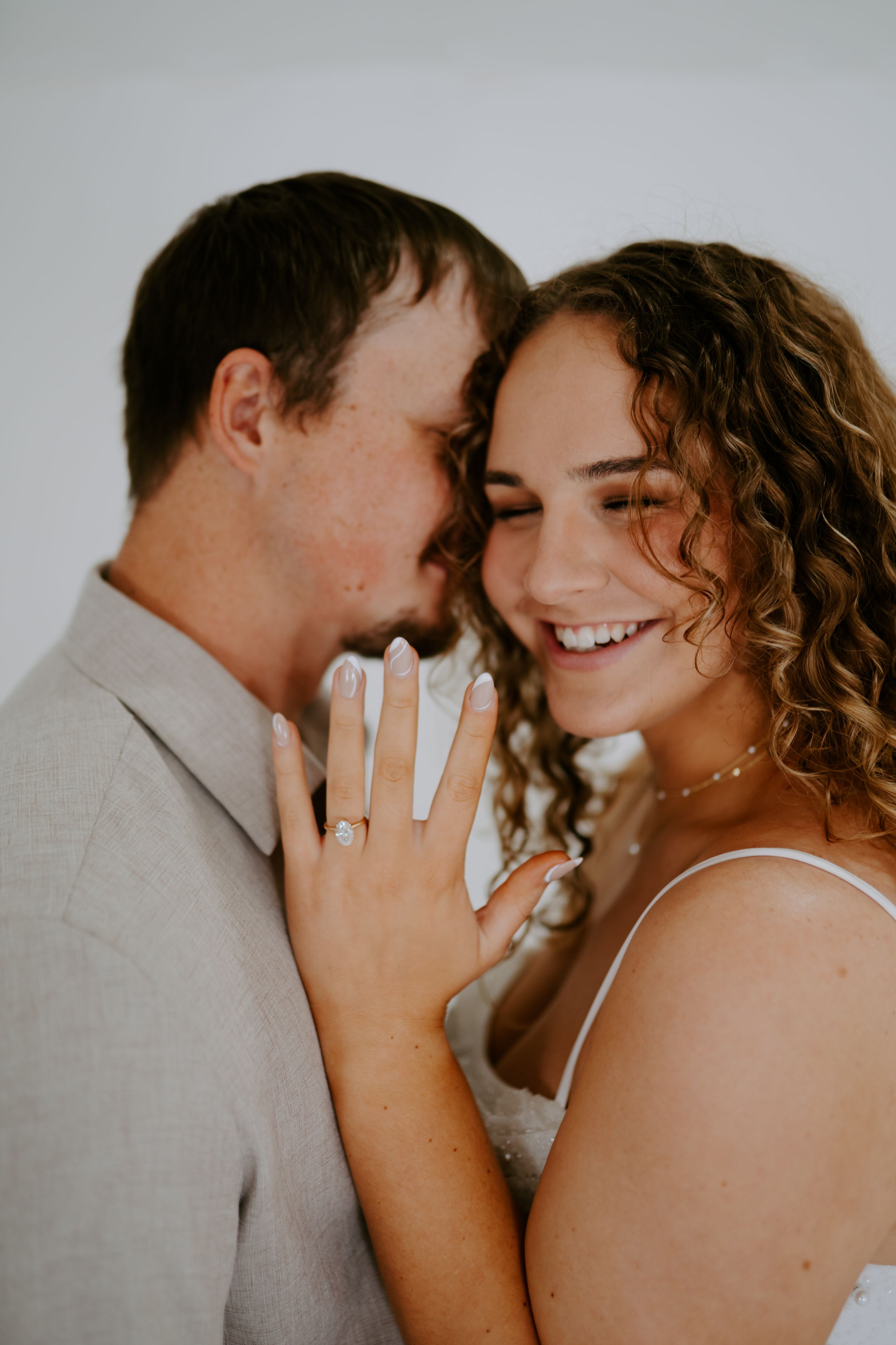 Close-up series highlighting joyful expressions and curly hair against light background.