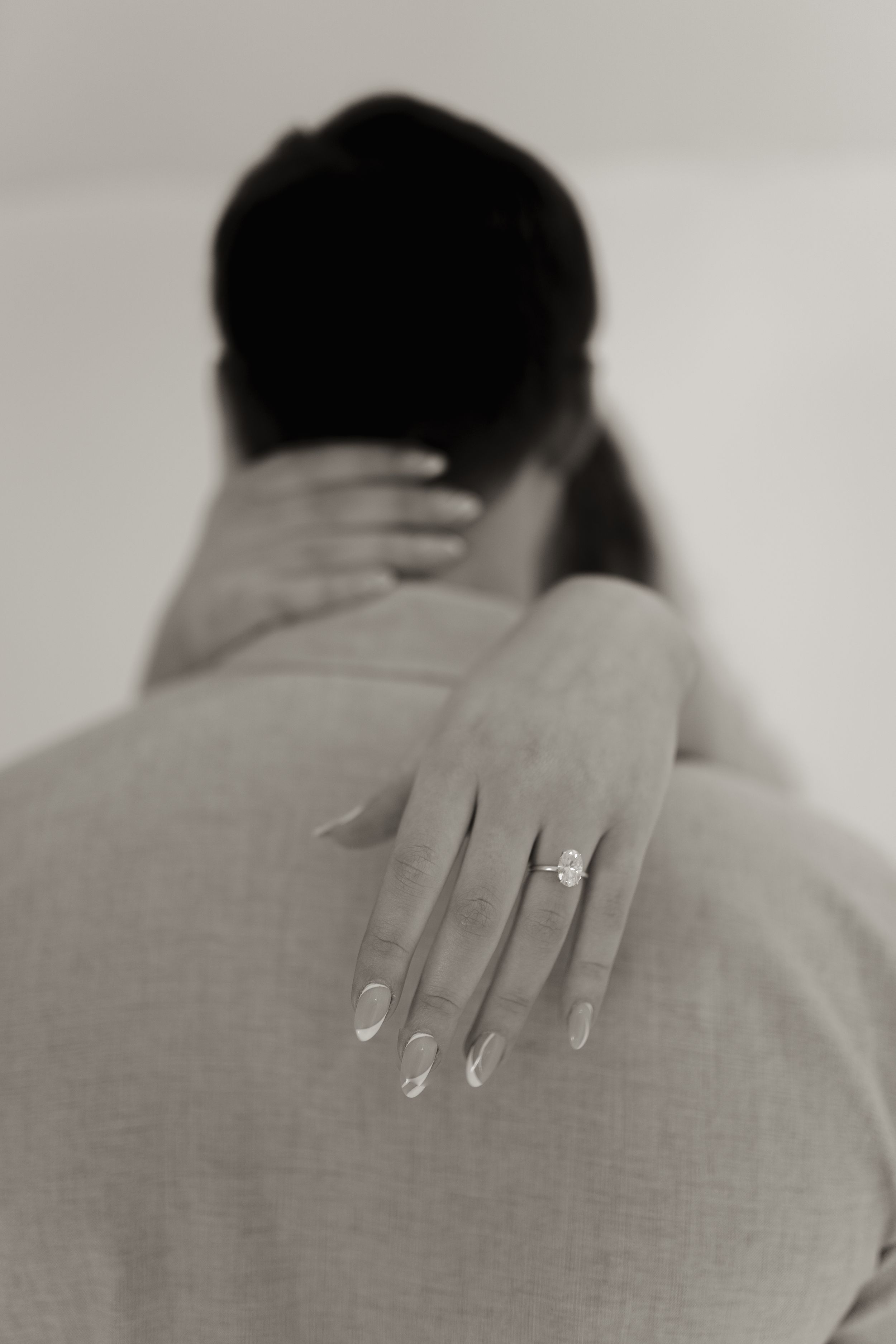 Close-up photographs featuring delicate hand poses and engagement ring details.