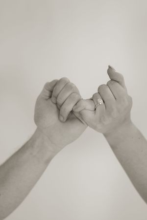 Black and white series showing pinky promise gesture between two hands.