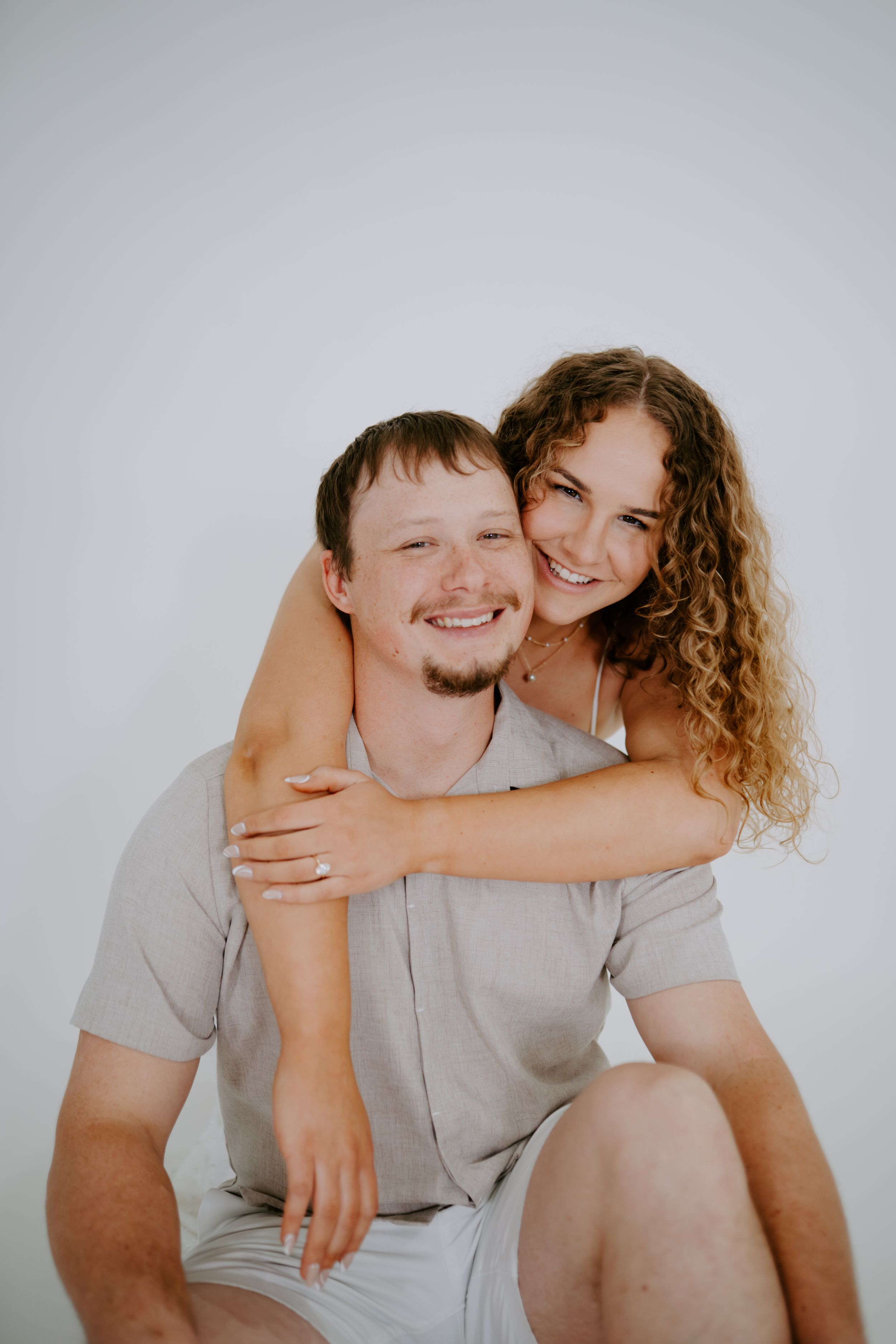 Playful studio portraits of couple showing natural chemistry and laughter.