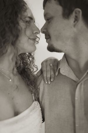 Intimate black and white wedding photo showing tender moment between couple.