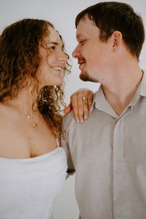 Joyful portrait showing natural smiles and curly hair against light background.