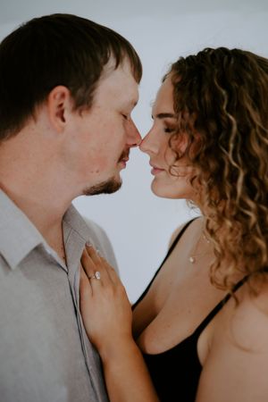 Intimate portrait showing tender moment between couple with curly hair.