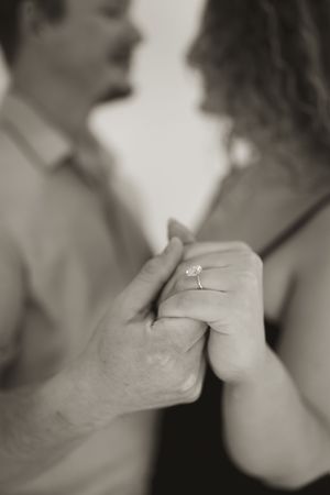 Series of black and white close-up shots showing hands with engagement ring.