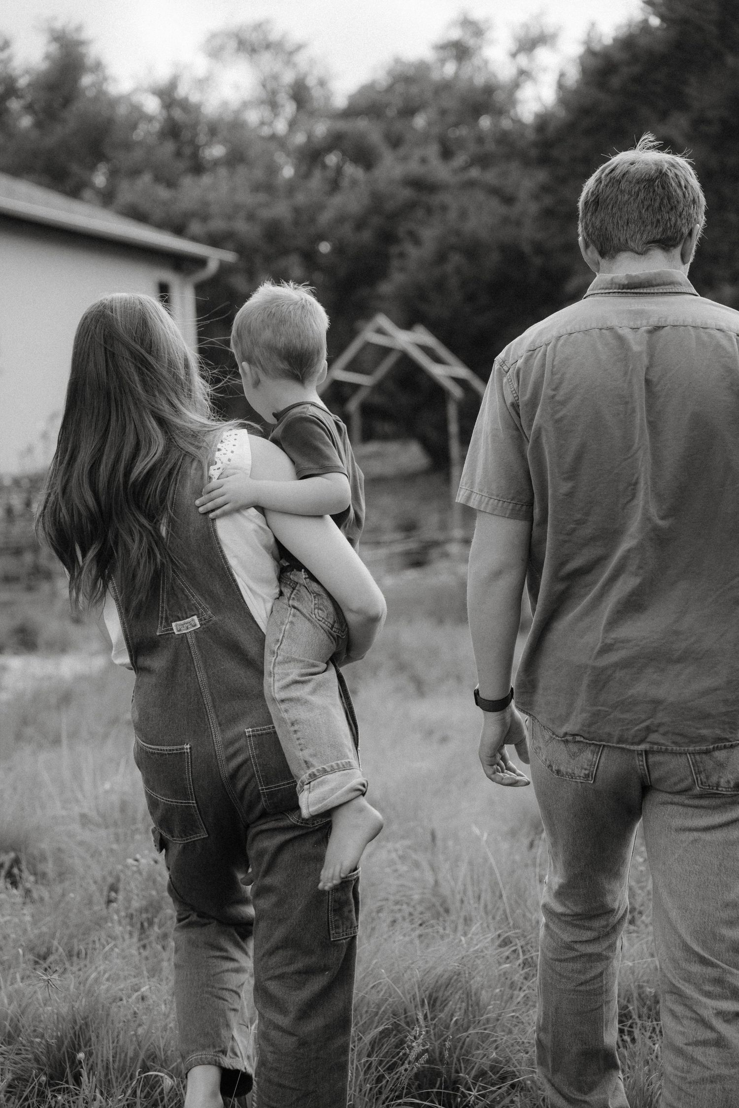 A series of black and white photos showing people walking together in a meadow or field.