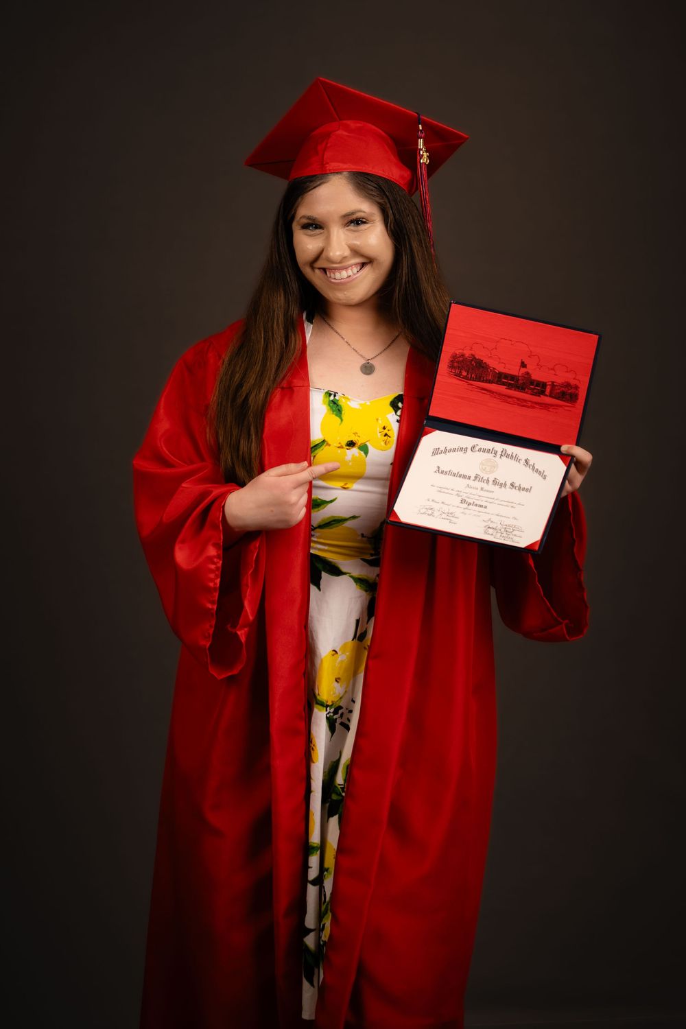 Cap and gown senior session, showing off diploma