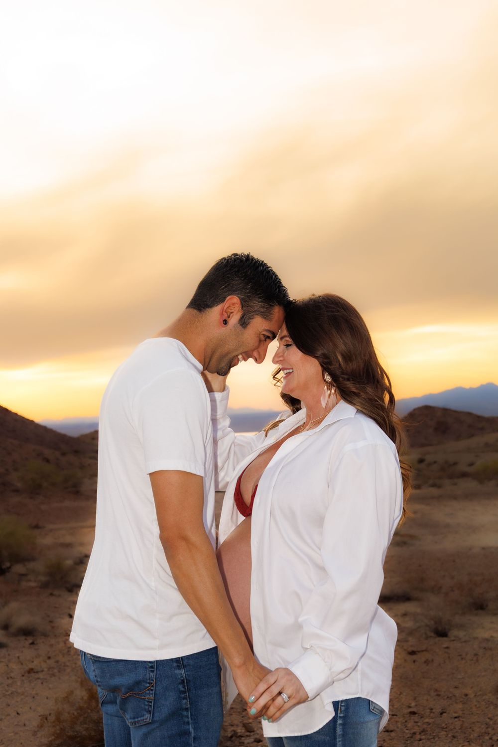 Romantic couple shares an intimate moment at sunset in a desert landscape.